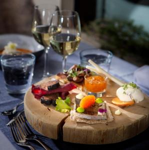 un plato de comida en una mesa con copas de vino en Lapland Hotels Riekonlinna, en Saariselkä