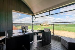 balcone con sedie e vista su un campo da golf di Lower Lodge Barn ad Alcester