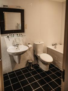 a bathroom with a toilet and a sink and a tub at Broadford Hotel in Broadford