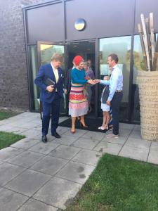 a couple of people shaking hands in front of a building at Resort Land & Zee in Scharendijke