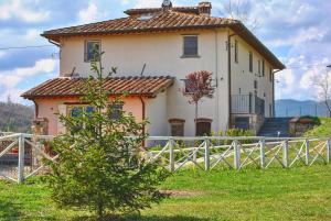 a large white house with a fence in front of it at La valle B&B in Cavriglia
