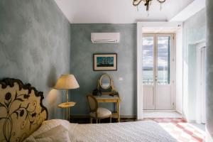 a bedroom with a bed and a desk with a mirror at Dimora di Ulisse Sea View Holiday Apartment in Syracuse