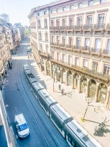 a train on the tracks in front of a building at Goodtime Apartments Strasbourg in Strasbourg