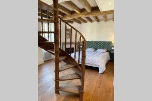 a bedroom with a spiral staircase next to a bed at La mystérieuse maison du Robimouth in Saint-Satur