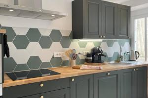 a kitchen with black cabinets and a hexagonal wall at La mystérieuse maison du Robimouth in Saint-Satur +5 photos