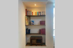 a room with a book shelf with books at La mystérieuse maison du Robimouth in Saint-Satur