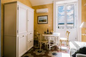 シラクーサにあるDimora di Ulisse Sea View Holiday Apartmentのダイニングルーム(テーブル、窓付)