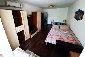 a bedroom with a bed with a red comforter at Studio in Bucharest