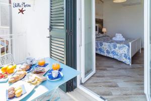 un tavolo blu con sopra del cibo e un letto di Quasi in Porto Rooms a Castellabate