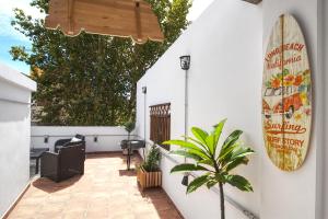 a patio with a surfboard on a white wall at Barceló 21, parking on request, Atico With terrace & Studio With Patio, Center, breakfast included, quite neighborhood, BC in Málaga