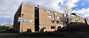 a brick building with a sign in front of it at Lancaster Hotel in Uxbridge