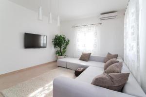 a white living room with a couch and a tv at Apartment Marcela in Sutivan