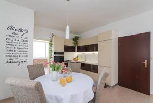 a kitchen with a white table and chairs in a room at Apartment Marcela in Sutivan