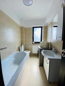 a bathroom with a large tub and two sinks at Copou Residence in Iaşi