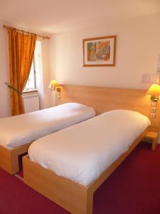 Habitación de hotel con 2 camas y ventana en Logis Auberge de l'Isard en Saint-Lary