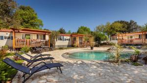 a patio with chairs and a pool in a yard at Mobile Homes Camp Green Garden Veštar in Rovinj