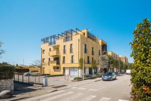 a yellow building with a car parked in front of it at Apartment Residence Poreč in Poreč