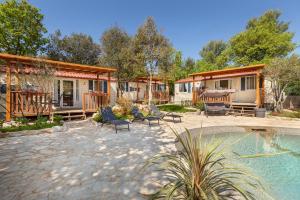 a group of cottages with chairs and a pool at Mobile Homes Camp Green Garden Veštar in Rovinj
