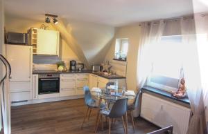 a kitchen with a table and chairs and a window at Ferienwohnung Ankerlicht2 in Westerland