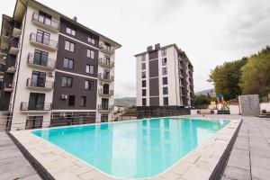 a large swimming pool in front of two buildings at Mint Apartment Солнечное Закарпатье in Polyana