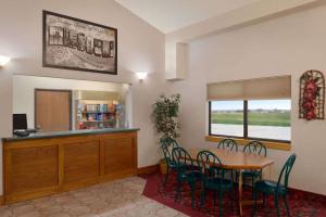 a dining room with a table and chairs and a counter at Super 8 by Wyndham Bethany MO in Bethany