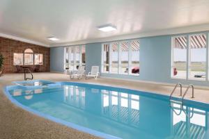 a swimming pool in a house with blue walls and windows at Super 8 by Wyndham Bethany MO in Bethany
