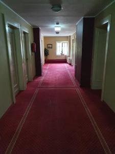 an empty hallway with a red carpet in a building at Hotel Casino im Park in Kamp-Lintfort