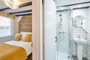 a bathroom with a bed and a shower and a sink at Host & Stay - Thimble Cottage in Whitby