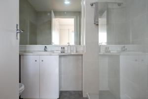 a white bathroom with two sinks and a mirror at Amazing Tailor Made Penthouse by the Beach #1 in Oeiras