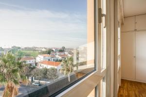 a large window with a view of a city at Amazing Tailor Made Penthouse by the Beach #1 in Oeiras