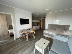 a room with a bed and a table and a couch at Apartament W Baltic Cliff in Niechorze