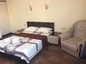 a bedroom with a bed and a couch and a chair at Nadezhda Guest House in Adler