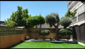 a yard with a fence and trees and grass at SeaHomes Vacations, FENALS BEACH&CHIC, pk, top apartment full equipped in Lloret de Mar