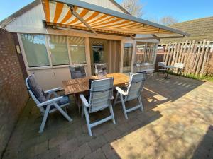 a wooden table and chairs on a patio at Rekerlanden 119 de Amandelbloesem in Schoorldam +32 photos