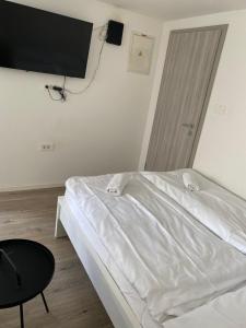 a bedroom with a white bed and a tv on the wall at Blue Casa in Koper