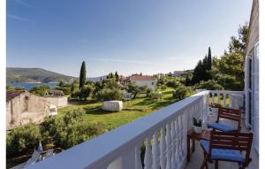 a balcony with two chairs and a view of a yard at Bijela Villa in Slano
