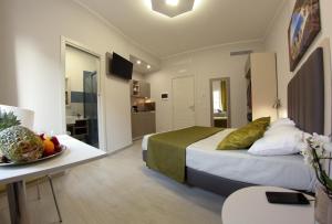 Cette chambre comprend un lit et une table avec un bol de fruits. dans l'établissement YEASY smart rooms Cefalù, à Cefalù
