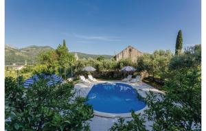 a swimming pool in a garden with chairs around it at Bijela Villa in Slano