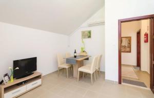 a living room with a dining table and a television at Bijela Villa in Slano