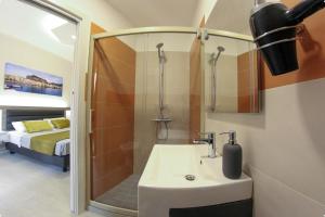 a bathroom with a sink and a shower at YEASY smart rooms Cefalù in Cefalù +60 photos