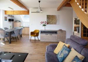 a living room with a blue couch and a table at Gite des Merles in Mittelwihr