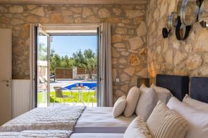 a bedroom with a bed with a stone wall at Ionio villa Zafeiris in Vasilikos