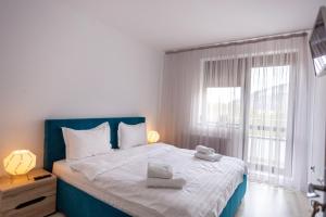 - une chambre avec un grand lit et des serviettes dans l'établissement Bucegi View 39 - Colina Marei, à Sinaia