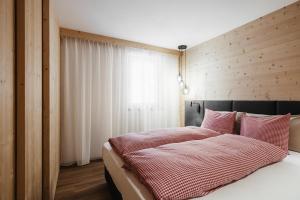 una camera con un letto e una parete in legno di Appartamenti Ciasa Hanny a Colfosco