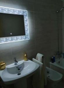 y baño con lavabo, espejo y bañera. en Apartamento Rodeira, en A Illa de Arousa