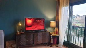 un televisor sentado en un tocador en una habitación con ventana en Apartamento Rodeira, en A Illa de Arousa