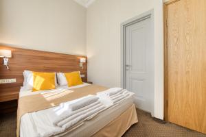 a bedroom with a bed with yellow and white pillows at отель Риверсайд Коломенское in Moscow