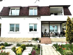 a white house with a garden in front of it at Villa Strashimirovo in Strashimirovo