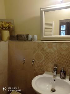 a bathroom with a sink and a mirror at Agula Relais camera matrimoniale in Pugnano +17 photos