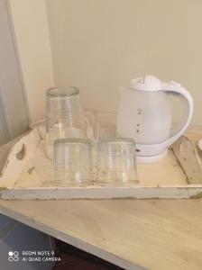 a tray with glasses and a tea pot on a table at Agula Relais camera matrimoniale in Pugnano